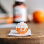 "A Vitamin D supplement pill placed on a wooden table."